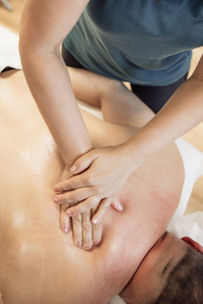 prsty zaborené do chrbátu klienta pri športovej masáži